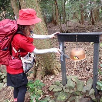 釜を加工した熊除けの鐘を叩く