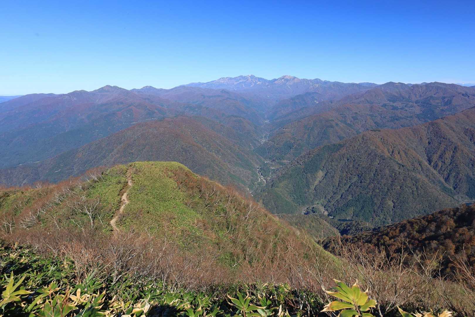紅葉🍁の山々の奥に聳える霊峰白山

遠くの山肌は
紫がかって見えます