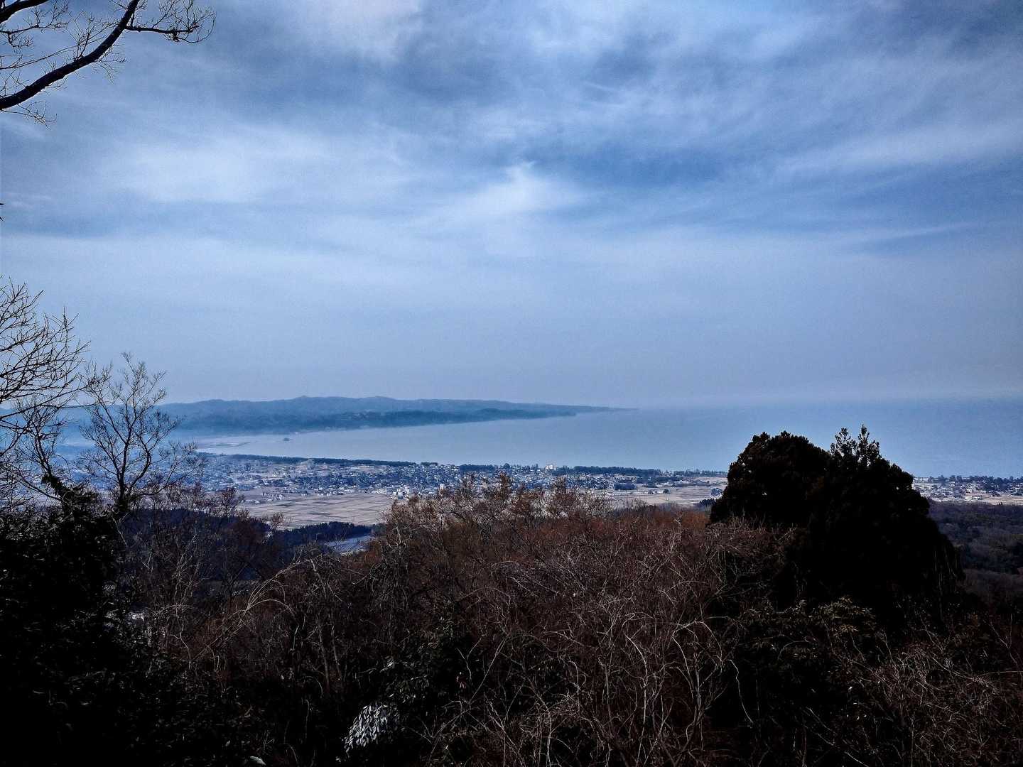 穏やかな富山湾と能登半島の付け根氷見市が見えます。