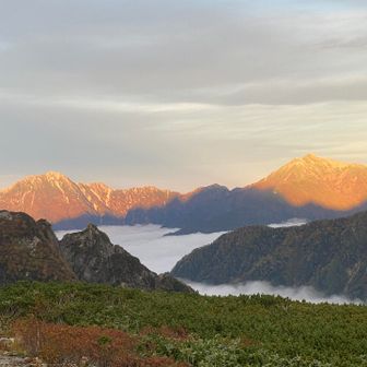 食事が終わったタイミングで、小屋番さんが「前の山に影劔が写っている」と教えてくださり、みんなで撮影タイム。
ちなみに左の山が雲海に浮かぶ五竜岳で右が鹿島槍だそうです。