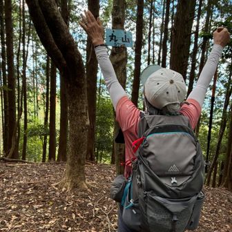 丸山到着。
バンザイしてみた。
あらら、手の向きがバンザイではなく『降参』になっている。
バンザイの時は左右の手のひらが向き合うように上げるのが正しい、と昔偉いセンセーから教わった。
この後、次のピーク西山に向かって歩いていたつもりが、あれ？なんか違うみたい！立ち止まり YAMAPの地図を確認するととんでもない方向に進んでいることが判明。引き返し正しいコースに戻った。YAMAP様様だね、と話しながら歩く。