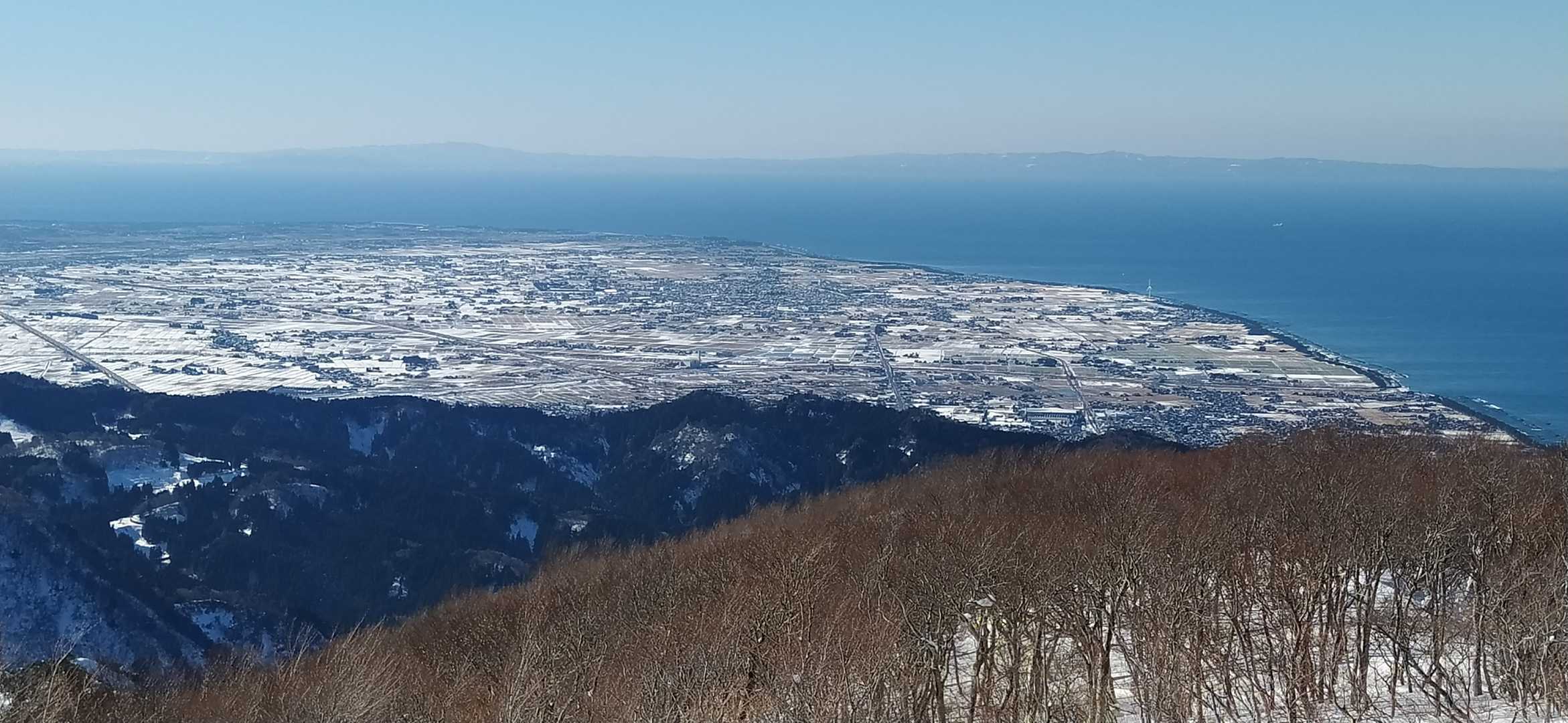 黒部扇状地も雪化粧。奥に能登半島（今日は先端まで見えました）。