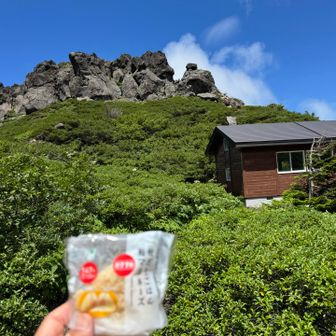 まだ山頂周辺は風が強くてガスだったので、避難小屋と平笠不動の岩峰を眺めながら🍙タイムです😋