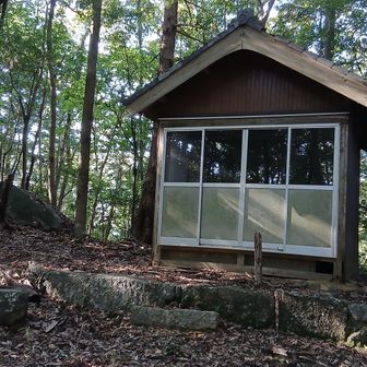 城址から岩谷山へは、まずこの小屋が目印。墓地を抜け、案内板の矢印通りの方向を向くと…