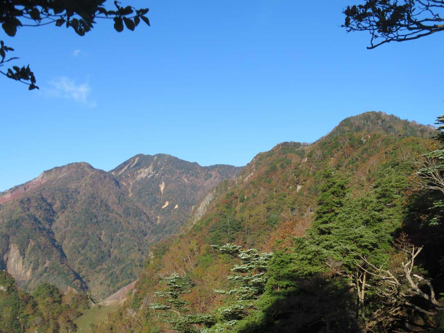 赤薙山山頂の樹幹から展望。前女峰(左)--女峰山-(中央左)--奥社跡の山(右)？目的地が遠いです。