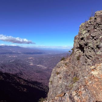 御座山の絶壁と遠くに北アルプス