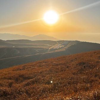 草千里の向こうに太陽が沈みます。