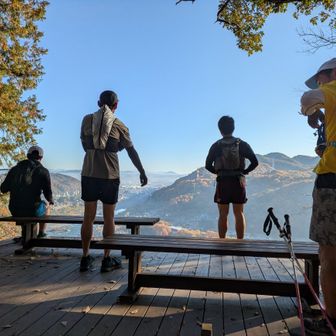 奥に見える白くなった中央アルプスとランナー