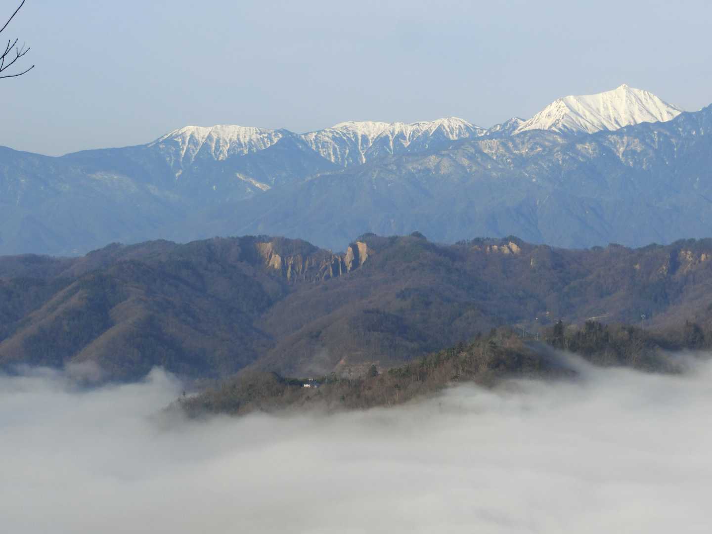 雲海の向こうに、池田町の継子落としの断崖。
背景には常念岳。