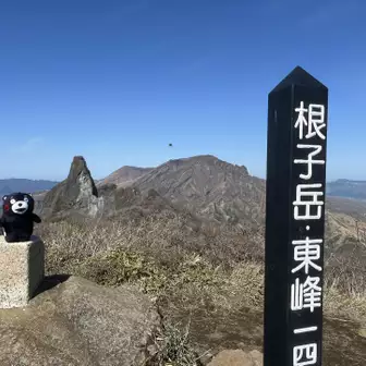 くまモンとローソク岩と高岳、根子岳標識の共演